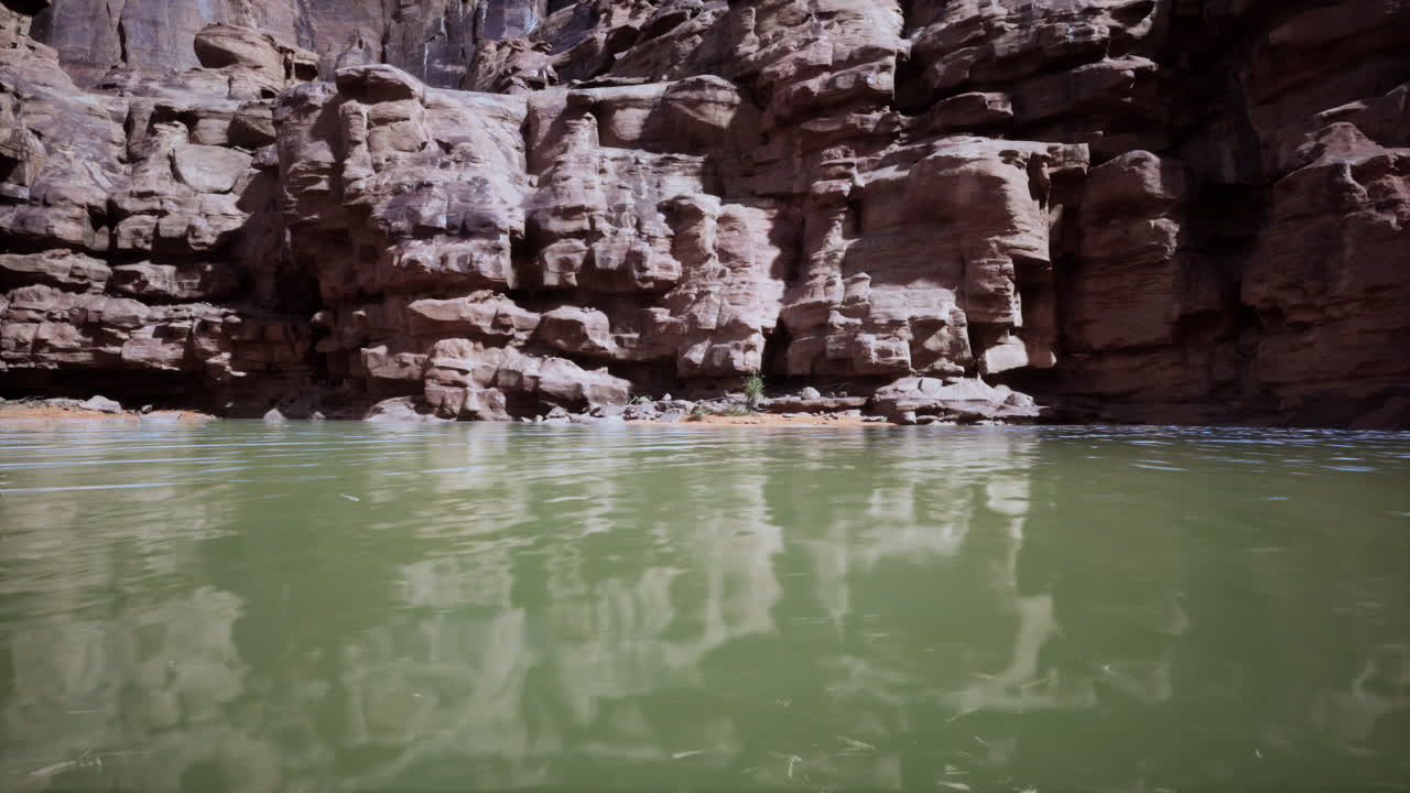 Fredfyldt Colorado River, der flyder ved siden af majestætiske klippevægge i dagslys