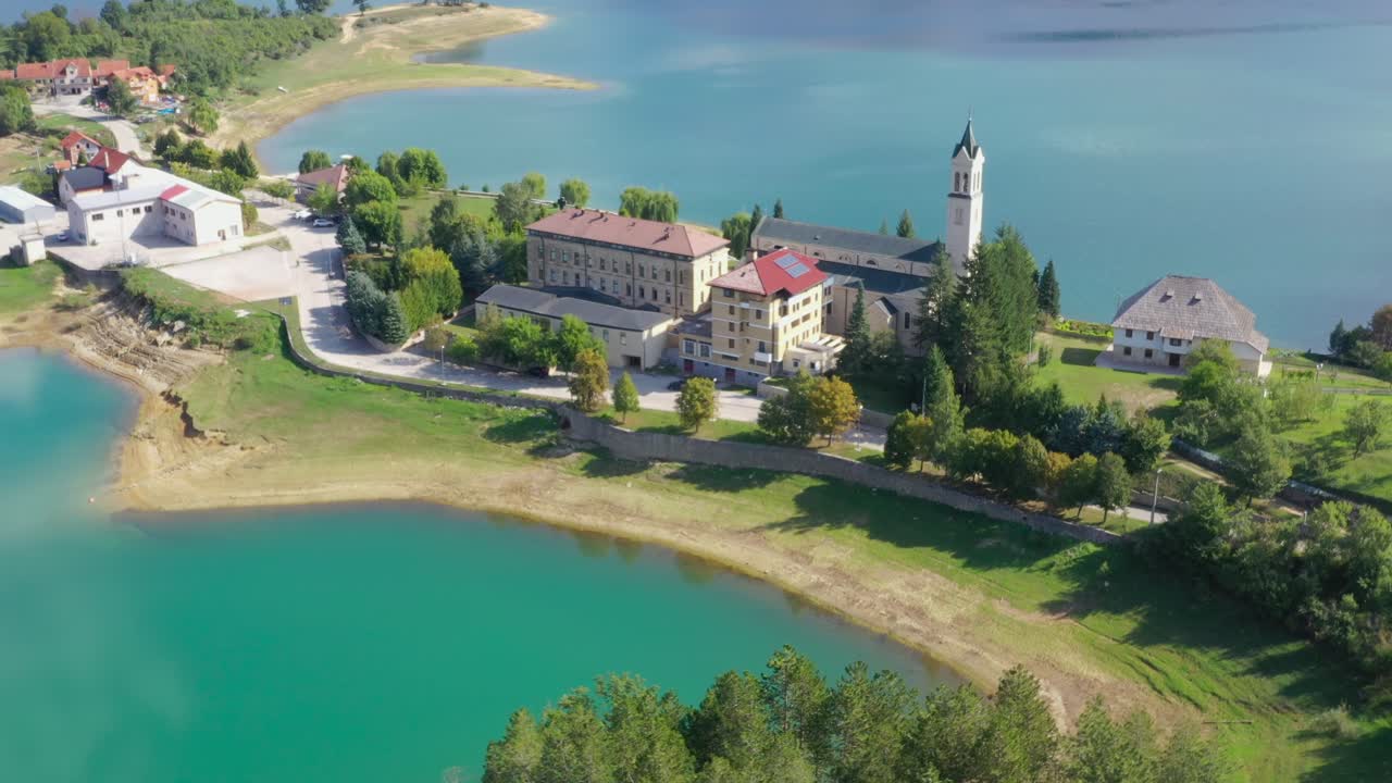 Rama Lake in Bosnia and Herzegovina with Franjevacki samostan Monastery below, Aerial flyover shot