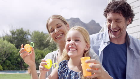 Happy-family-blowing-bubbles-in-the-yard-at-home