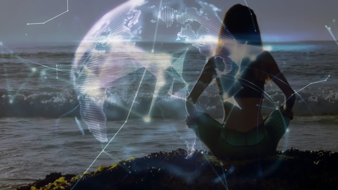 Meditating by ocean, person with digital globe animation overlay in background