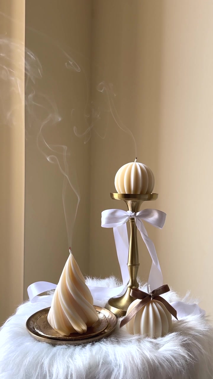 Bougies décoratives élégantes avec de la fumée montante sur une surface douce