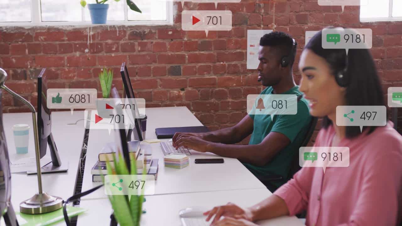 Two coworkers typing, incoming badges multiplying and covering screens to show social media surge