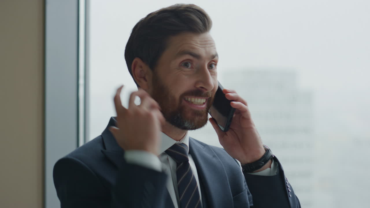 Portrait furious manager calling phone gesturing emotionally at office window.