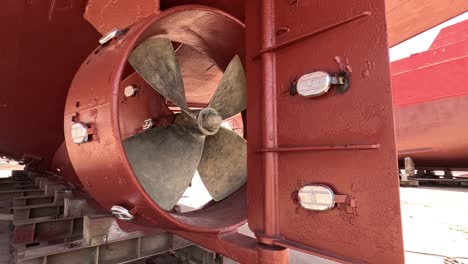 Close-up-view-of-a-boat-propeller-in-a-dry-dock-repair-station,-where-precision-and-expertise-are-key