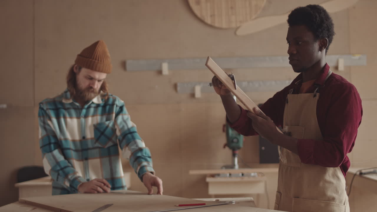 African American and Caucasian Craftsmen Working in Joinery Workshop