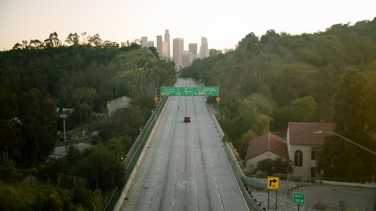 A view of an empty freeway in Los Angeles with the downtown skyline in the distance
