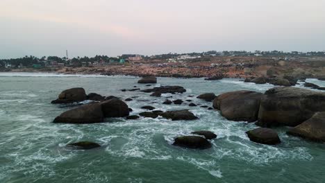 aerial drone shot showcasing kanyakumari’s iconic shoreline, ocean, and city during the golden hour.