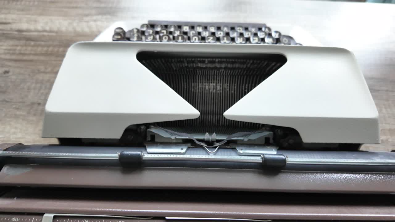 Typing on a white typewriter, zoom out