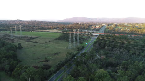 Líneas-Eléctricas-Suspendidas-Unidas-Por-Encima-De-La-Carretera-Del-Cinturón-Verde-Y-La-Infraestructura-Vial-Con-Hermosas-Vistas-A-La-Montaña-En-La-Distancia