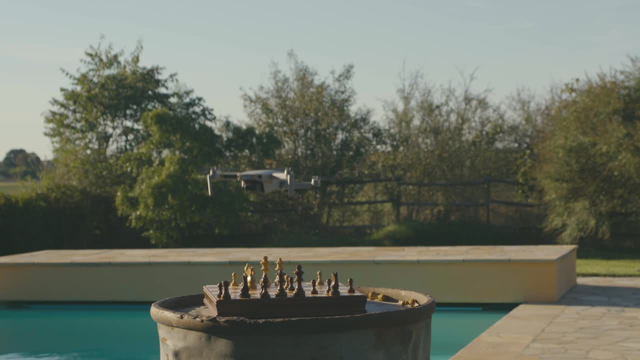 드론이 날아간 다음 체스판에 떨어져 모든 조각이 날아가고 소년이 그것을 잡으려고 달려갑니다.