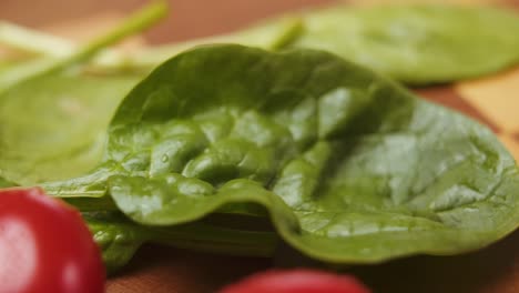 revealing fresh spinach and tomatoes on a cutting board