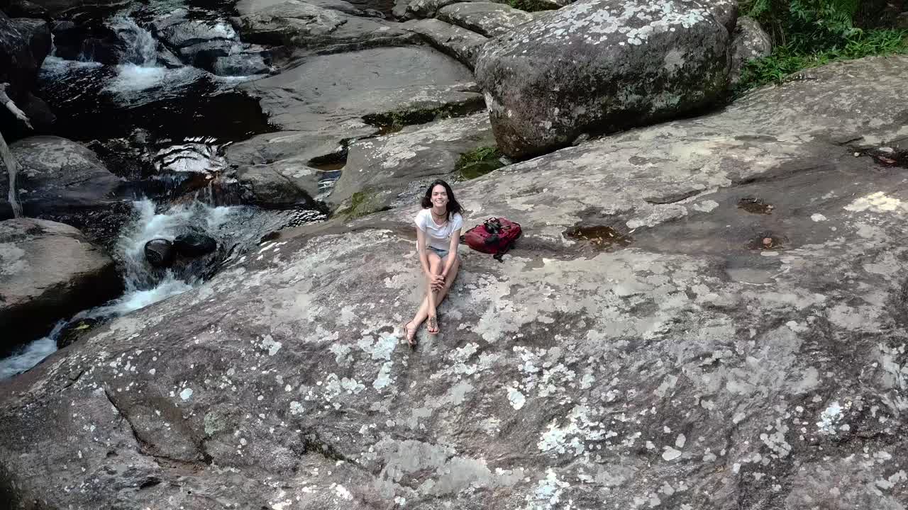 폭포 근처에 앉아있는 소녀의 환상적인 공중  ⁇