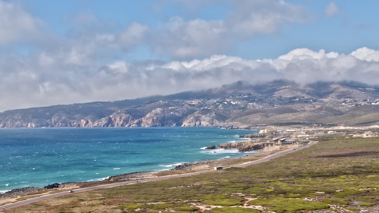 Coastal view of Portugal with hills and ocean under a cloudy sky