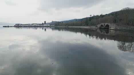 low aerial track right to left of aray bridge with inveraray village in background