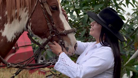 Brown-with-white-horse-being-petted-by-her-happy-cow-girl