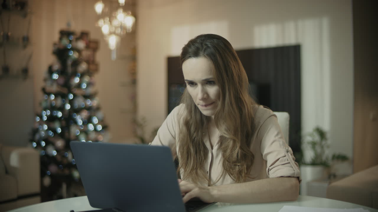 mujer joven trabajando en una computadora portátil en casa de navidad
