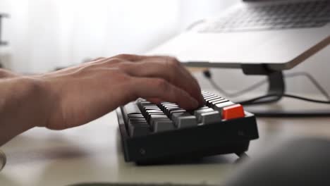 male hands start to type at a fictitiously high rate of speed on a wireless computer keyboard