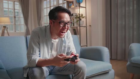 happiness adult mature asian male hand playing online game by smartphone with fun and exited cheerful in indoor