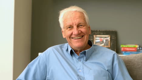 Happy-retired-man-smiling-on-couch