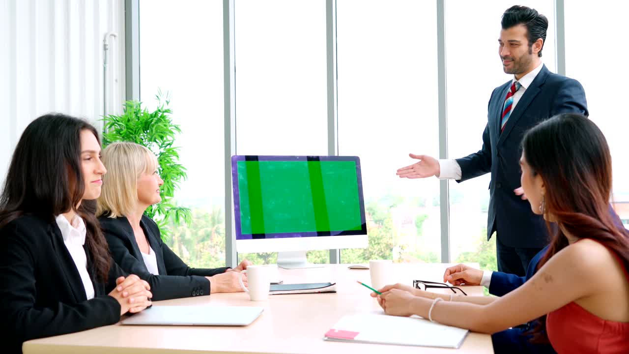 녹색 스크린을 가진 회의실에 있는 비즈니스 사람들