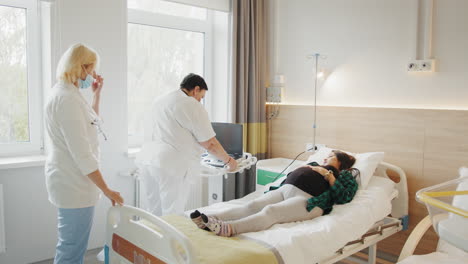 mujer embarazada recibiendo ultrasonido en la habitación del hospital