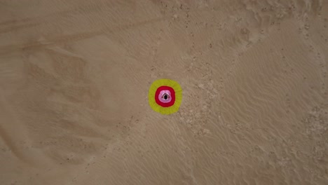 Frau-Sitzt-Auf-Sanddüne-In-Buntem-Bullseye-Kleid-Und-Steigt-Aus-Der-Luft-Auf