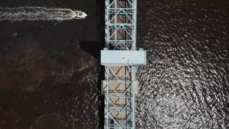 aerial view of top of the bridge speedboat passing by in water sun reflecting water