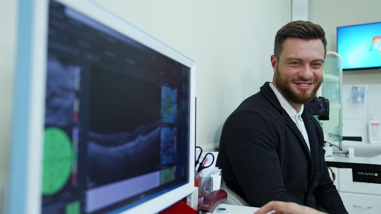 Young man visiting an ophthalmologist. Side view of optometrist doing sight testing for patient