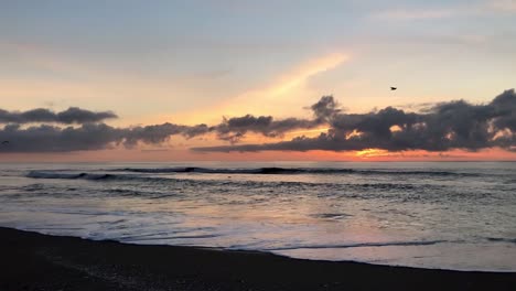 Die-Silhouette-Der-Möwen,-Die-Bei-Sonnenuntergang-Am-Strand-An-Der-Küste-Oregons-Entlangfliegen