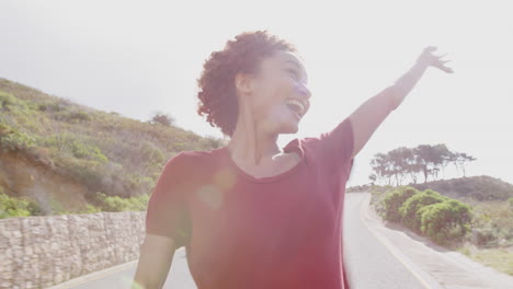 young female passenger standing up in open top hire car on summer vacation