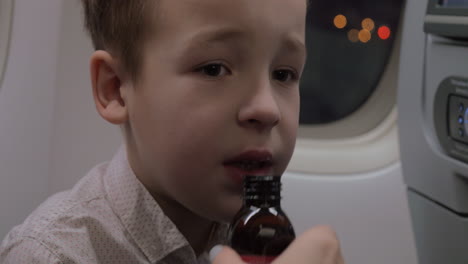 niño en el avión tomando medicina