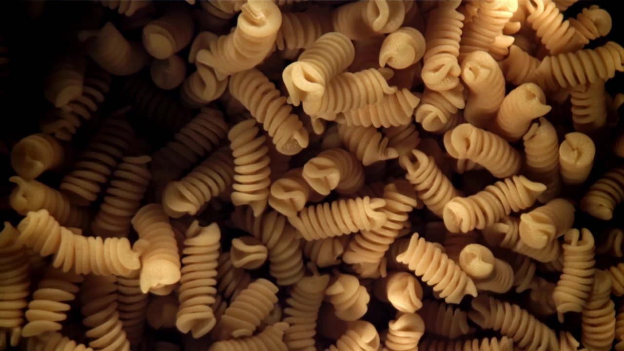 Primo piano di pasta fusilli secca con luce cangiante