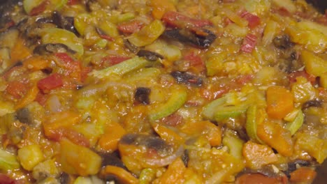 oregano sprinkling on steaming spanish pisto, extreme closeup