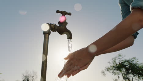 Bäuerin-Wäscht-Sich-Die-Hände-Unter-Leitungswasser-Auf-Dem-Ländlichen-Bauernhof-Mit-Süßwasser,-Das-Aus-Dem-Wasserhahn-Fließt,-Mit-Nachmittäglicher-Sonneneinstrahlung