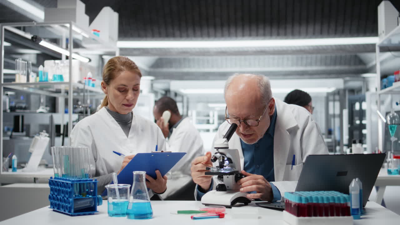 Team af cytoteknikere analyserer et bakteriekulturslide.