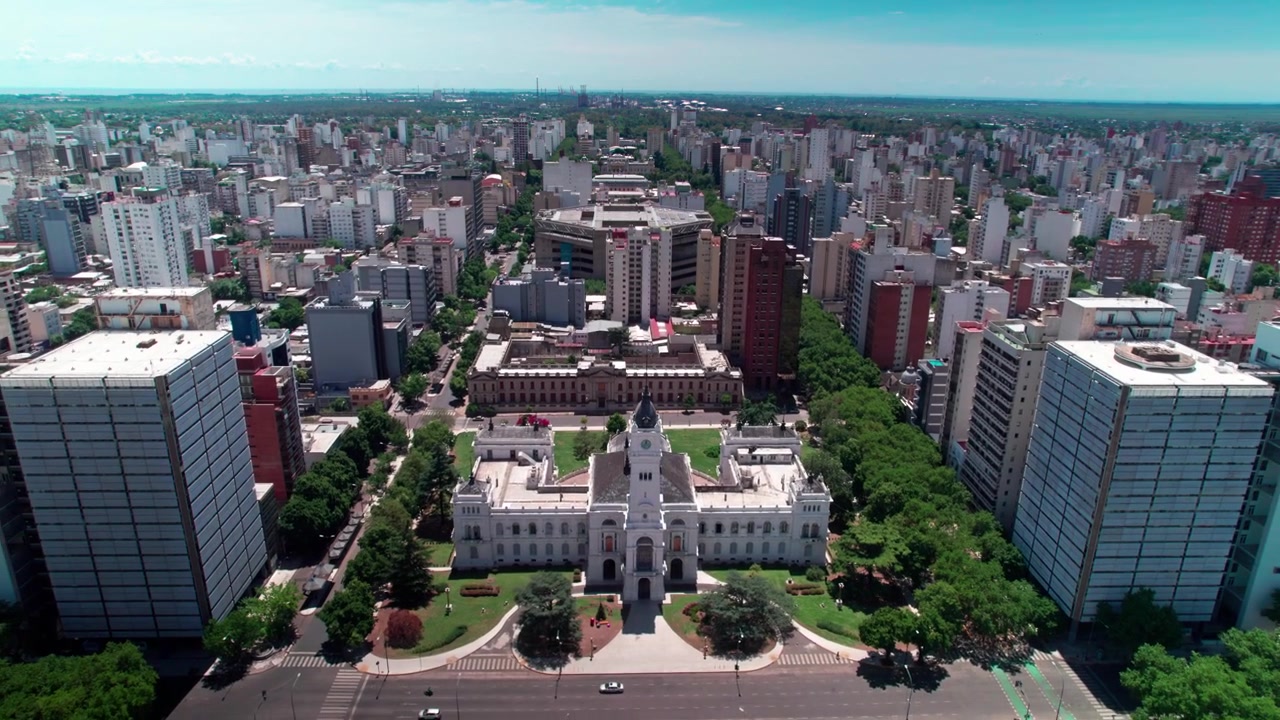 Aerial drone dolly out shot pulling back over Plaza Moreno, exposing the German Neo-Renaissance City Hall, Brutalist Argentino Theater, and planned urban grid in La Plata, Argentina