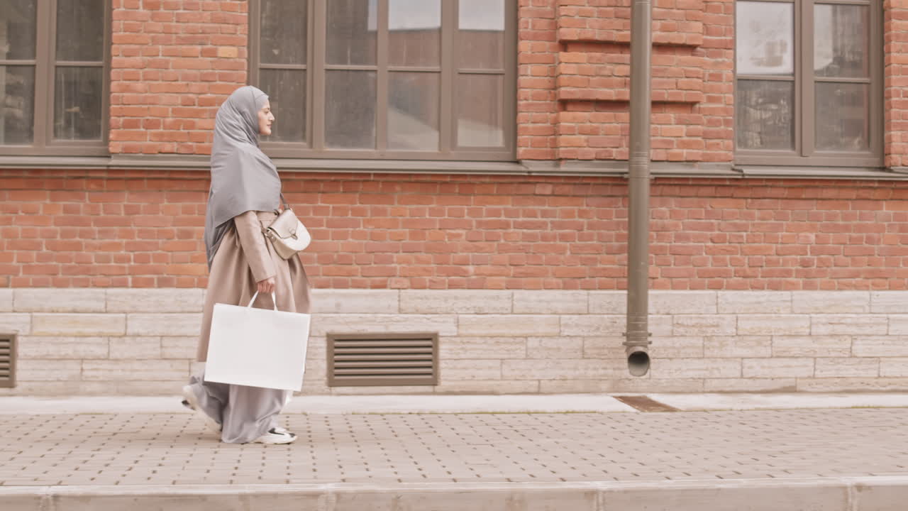 Arabic Woman Walking along Street after Shopping