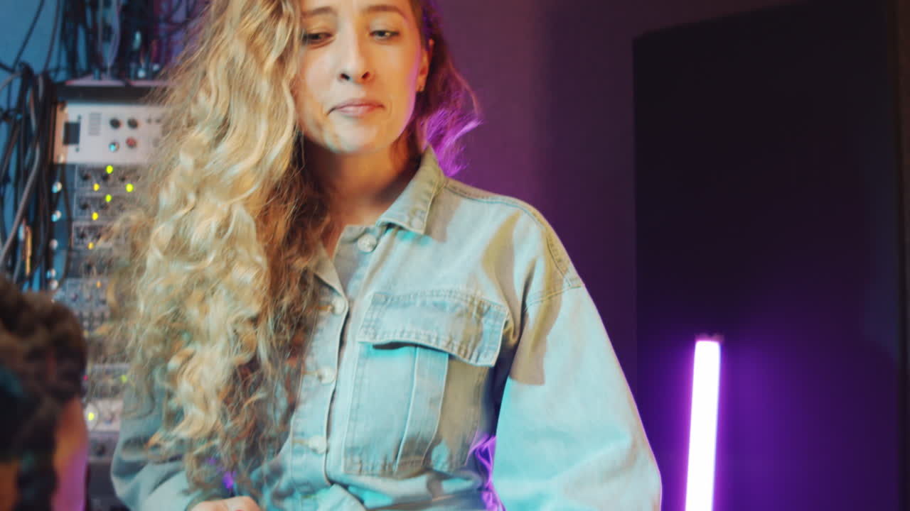 dúo multiétnico cantando con la guitarra en un estudio de grabación