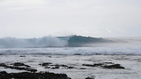 Ultra-slow-motion-shot-of-big-wave-and-surfers-in-the-ocean-at-Asu-Island,-North-Sumatra,-Indonesia