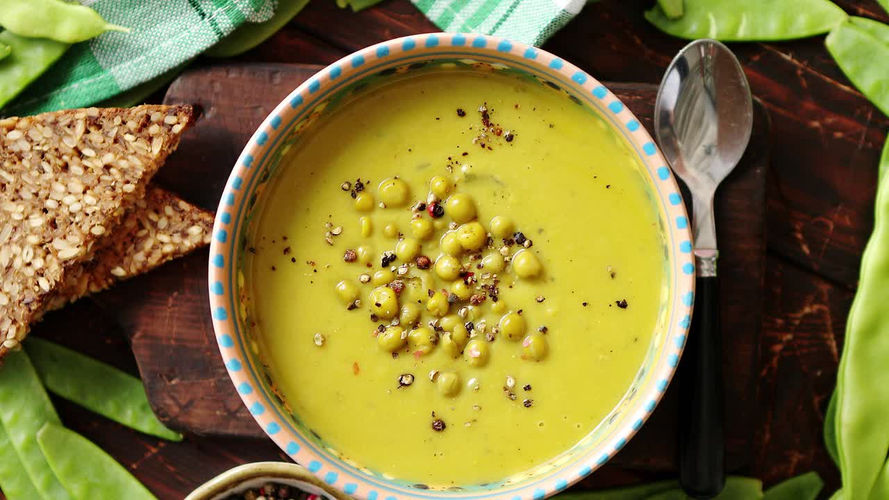 sopa de crema de guisantes verdes en tazón gris