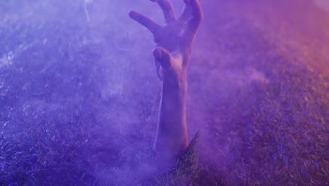 video of hand raising from grass with smoke on black background