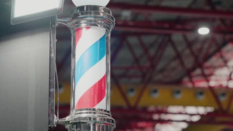 classic barber pole with swirling red, white, and blue stripes in a shop setting