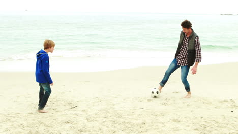 father and son playing football