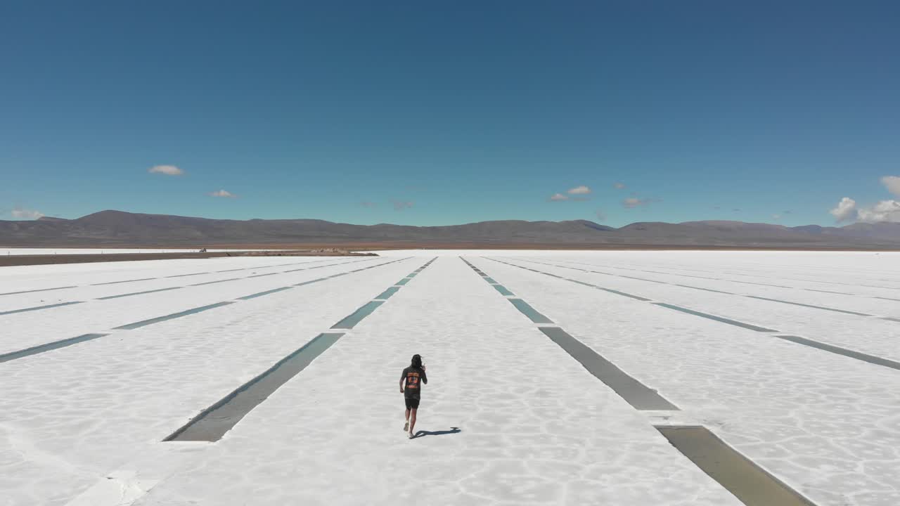 아르헨티나의 살리나스 그란데스 (salinas grandes) 의 소금 바닥의 채굴 구 ⁇ 이를 따라 달리는 외로운 인물의 항공