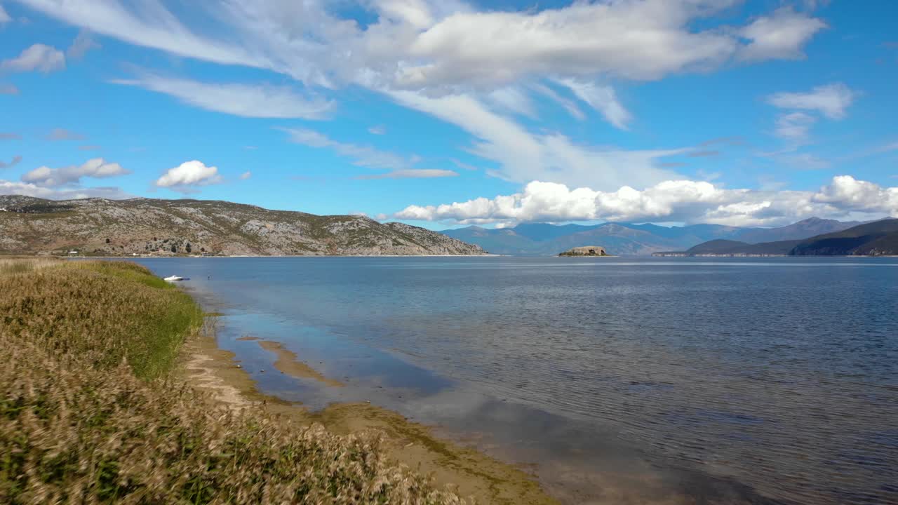 juncos en la orilla del lago prespa y vista aérea panorámica de las montañas bajo el cielo nublado