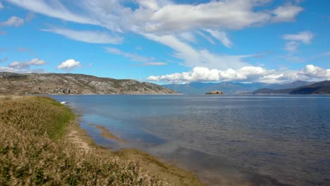juncos en la orilla del lago prespa y vista aérea panorámica de las montañas bajo el cielo nublado