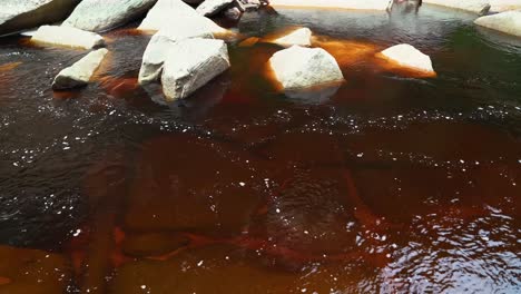 toma manual de 4k de un río carmesí lleno de minerales que proviene de las cataratas de mosquitos rodeadas de rocas blancas en el parque nacional chapada diamantina en el noreste de brasil en un día soleado de verano