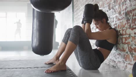 Vídeo-De-Una-Mujer-Caucásica-Cansada-Y-En-Forma-Relajándose-Después-Del-Entrenamiento-De-Boxeo-En-El-Gimnasio