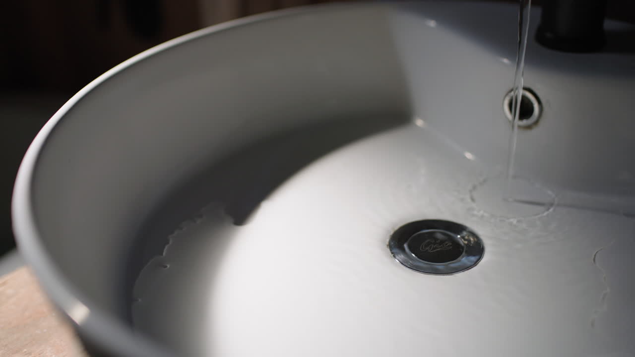 Moody shoot of water running into an empty sink.