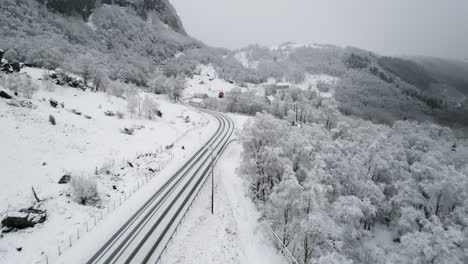 Drone-flying-over-snowy-Norwegian-National-Road-or-Riksveg-13-in-Norway